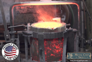 Melted bronze in cauldron ready to pour into molds for metal cast signs